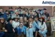 A group photo of people dressed in western Attire inside a hall.
