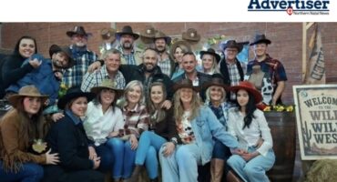 A group photo of people dressed in western Attire inside a hall.