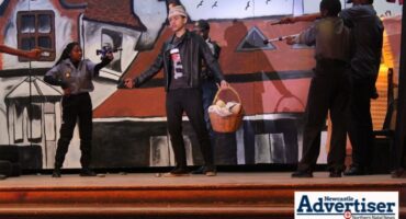 A photo of several learners dressed up during a stage production.
