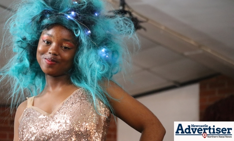 A young model is pictured with blue hair on the runway.
