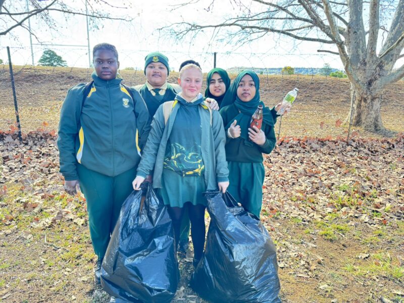 Image of learners holding rubbish and black bags.