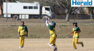 Image of Vryheid High School learners on a cricket pitch.