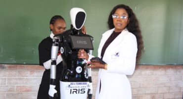 Image of Iris the South African developed 'robot' that assists school chidren in learning and teaching with its developer, Bonisiwe Gumede, and a learner.