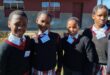 Image of four uniformed school girls outside Isandlwana Primary.