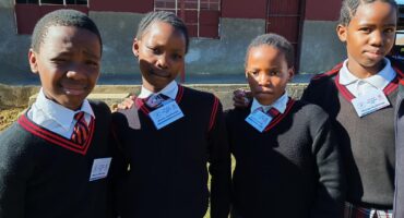 Image of four uniformed school girls outside Isandlwana Primary.