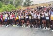 Image of marathon runners lined up behind a starting line.