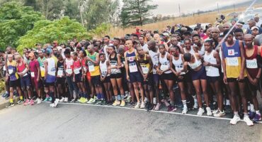 Image of marathon runners lined up behind a starting line.