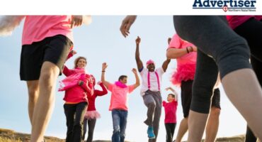 A photo taken of a group of road runners dressed in pink attire.