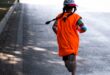 Image of a girl running on road with back to the camera.