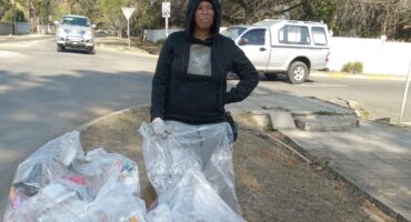 Image of a woman with litter she picked up and put in refuse bags.