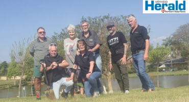 Image of men and women after they've planted a tree.