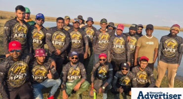 A group photo of an angling club posing at the dam during a compitition.