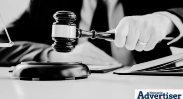 A black and white image of a judge holding a gavel.