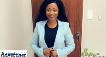 A portrairt photo of a female lawyer dressed in a black shirt and a light blue jacket.