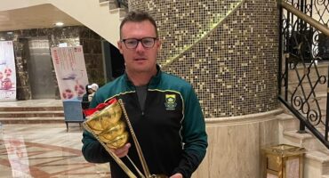 Photo of SA hockey men's under 21 coach Guy Elliott holding a trophy.
