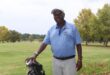 Image of a golfer holding a golf bag.