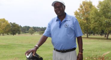 Image of a golfer holding a golf bag.