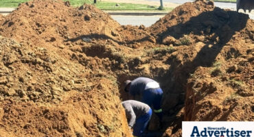 Workers photographed fixing a pipeline under ground.