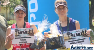 Two women holding their prizes and medals after completing the Memel to Newcastle Walk/Run.