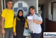 Three people stand in front of the Newcastle SPCA offices holding a cash donation.