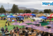 Image of tents, gazebos and people on a rugby field.