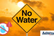 A yellow 'No Water' sign in front of a yellow sunny and cloudy background with the Newcastle Advertiser logo in the bottom corner.