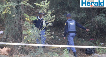 Image of two police officers in a cordoned-off area.