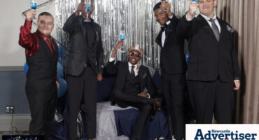 A photograph of a group of young men celebrating their matric farewell in font of a silver backdrop.