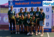 Netball players standing in front of Hoërskool Pionier's banner.