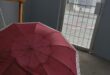 Image of an umbrella in the foreground with a glassdoor behind.