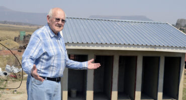 Image of a person with outstretched arms indicating an unfinished toilet block.
