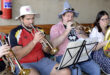 Image of men dressed in traditional German garb playing brass instruments.