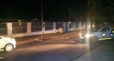 Image of a street light lying on the ground with security officials parked nearby.