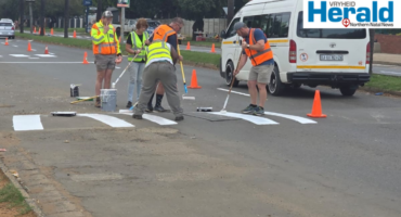 Image of people painting road markings in a street.