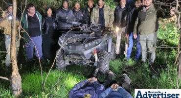 A group of crime fighters standing behind a stolen quad bike, while the two criminals lay face down on the ground in front of them.
