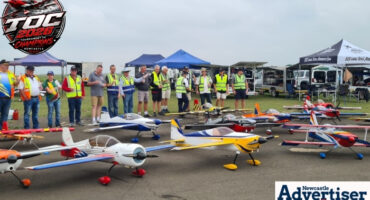 Several men are photographed with their model aircraft on the Newcastle Airstrip.