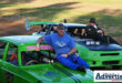 Two oval track racers are photographed sitting on the bonets of their racing cars.