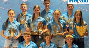 Image of young swimmers holding trophies.