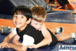 Two young children are photographed on the wrestling mat.