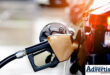A photo of a petrol station, with a petrol guzzle inside a vehicle tank.