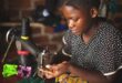 Image of a woman working on a sewing machine.