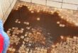 Image of brown water on a tiled floor.