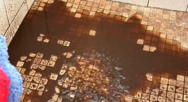 Image of brown water on a tiled floor.