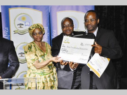 Thakane Matla (assistant registrar: committee relations) and Dr Abbey Ngoepe (director: quality assurance) congratulate Prof Tholene Sodi for winning the best established reseacher award.