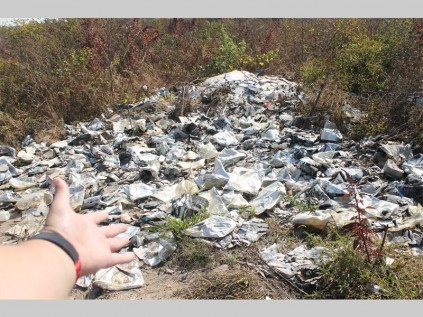Empty wine bags lie dumped behind a scrapyard in Lood Street