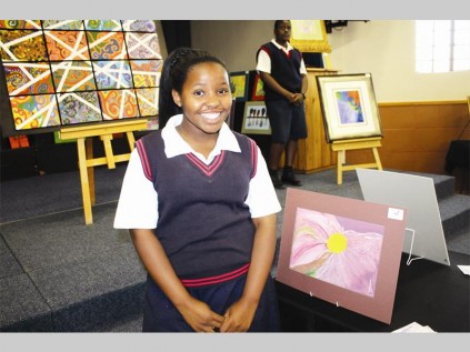 Tido Matsaung smiles proudly beside her artwork.