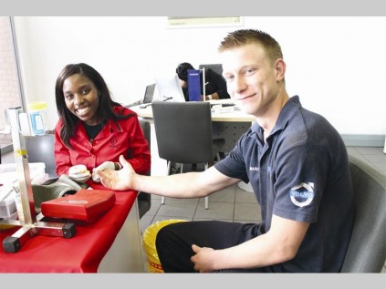 Rejoice Dube from the SANBS checks Edward Willis' iron levels before he donates blood.