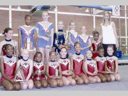 Ritmiese gimnaste wat wisseltrofees gewen het is voor Tshepo Kganyago, Monique Lange, Rotondwa Maudu, Schae Kaba, Tanja Mare, Khomotso Morokane, Niane Coetzee, Khensani Rivombo en Leandie Kriel. Agter is Ceciel von Beneke, Cleo-Anne Manamela, Monique Oelofse, Marinette Vorster, Simone Blaauw, Zanri Vorster en Melchi Maponya. Dene van der Merwe (afrigter) het die trofeë oorhandig.