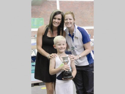 JC Oosthuizen wys die trofee wat hy as beste vlak een trampolienseun gewen het. Saam met hom is Joalette Botha en Tanya Bouwman, afrigters.