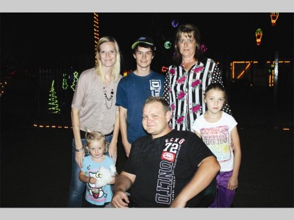 Vriende kuier saam by die Polokwane Kinder- en Gesinsorgvereniging se kantore onder die kersliggies wat die tuin versier. Voor sit Charice Bezuidenhoud, Malcolm Page en Nadia Schwan. Agter staan Monja Prinsloo, Gerhard Backhouse en Marie Prinsloo.